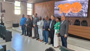 7 homens e duas mulheres de pé, lado a lado, para a foto. Evaristo é o primeiro da ponta à esquerda e usa camisa social azul.